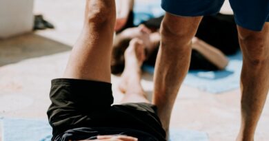 man lying on floor near man standing holding his leg