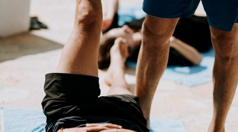 man lying on floor near man standing holding his leg