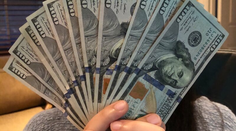 person holding fan of us dollar bill