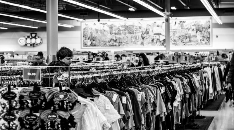 grayscale photography of people inside a clothing shop